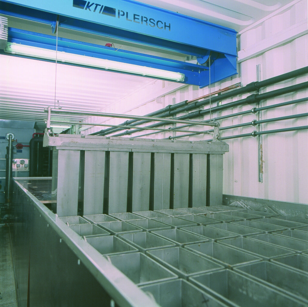 View into containerized block ice plant. Stainless steel crane and ice cans.